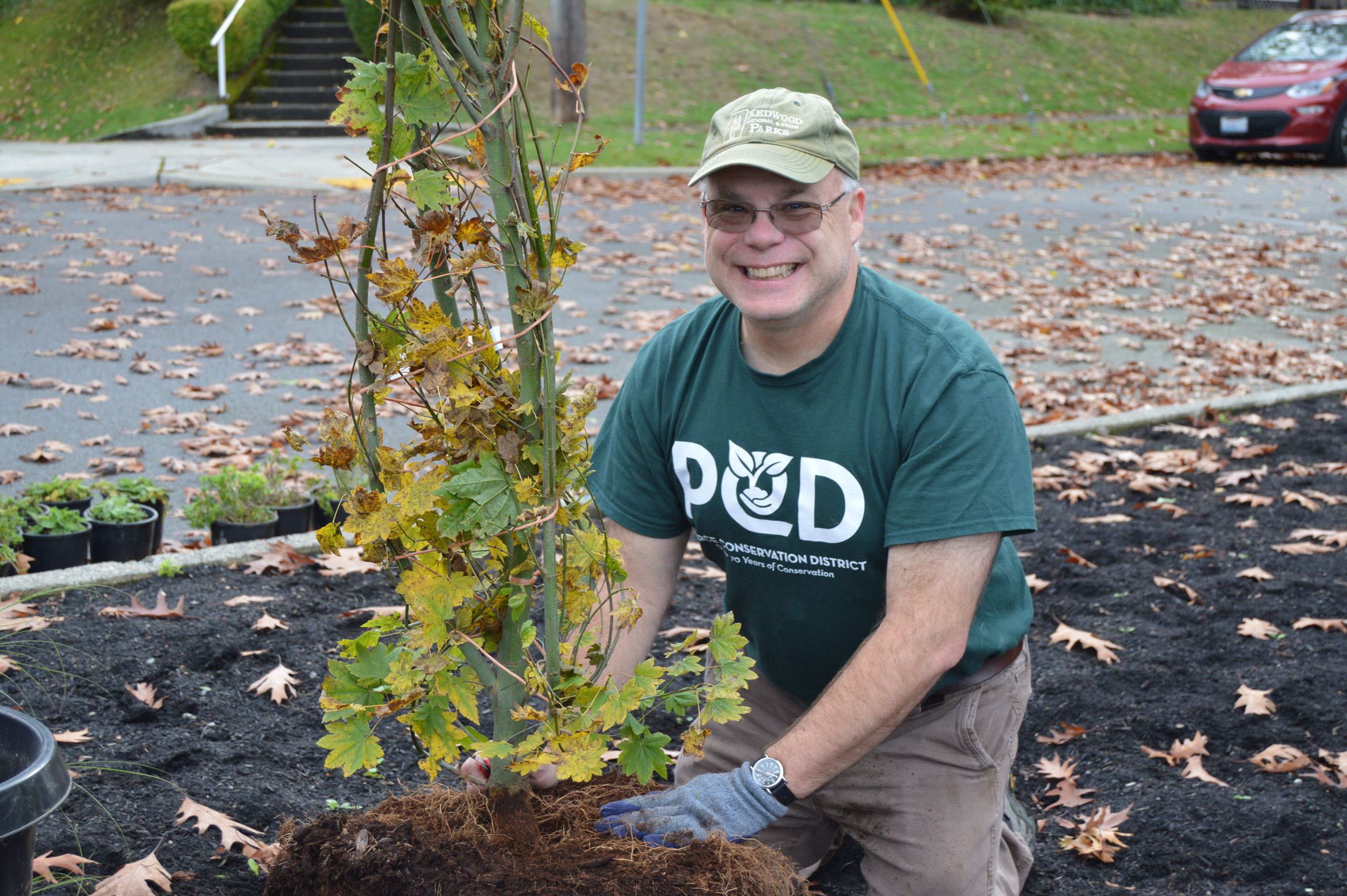 A PCD board member planting a tree.