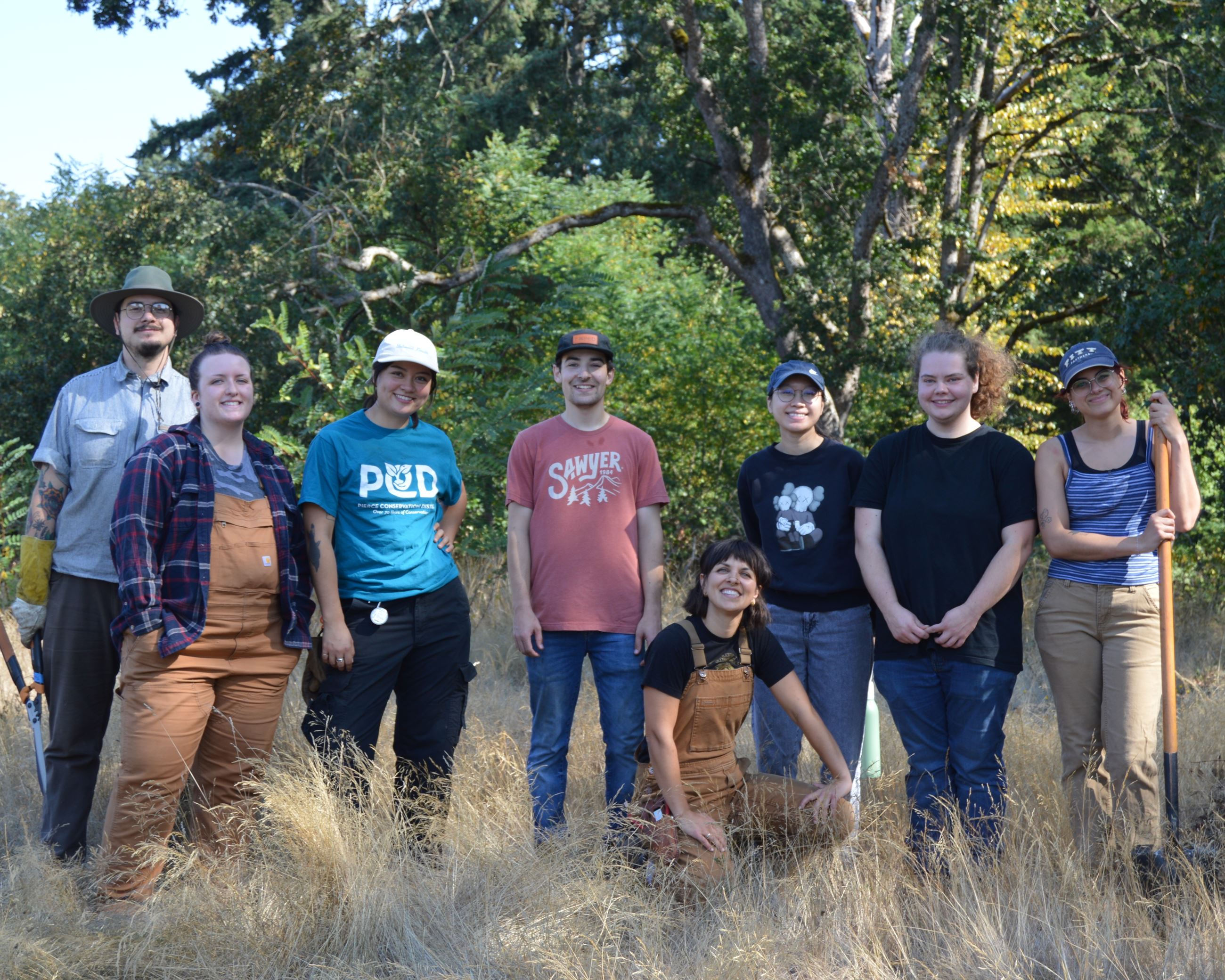 volunteers posing in front of oak trees in a field