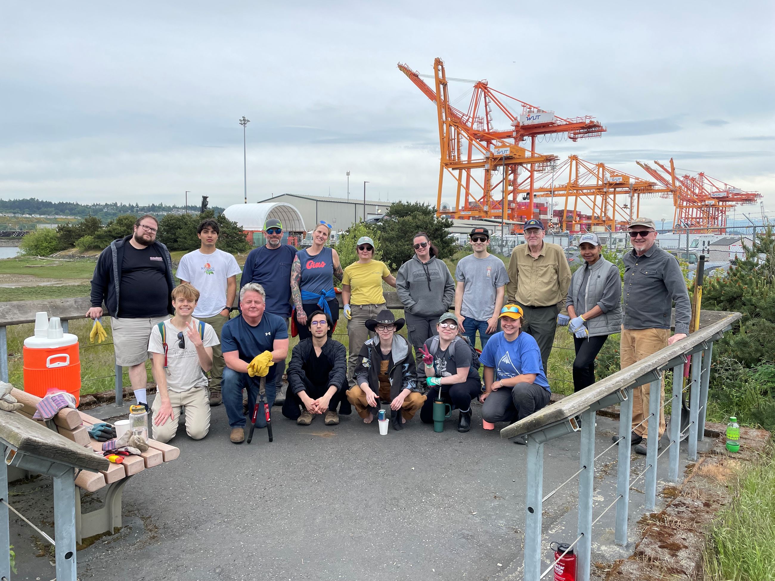 volunteers posing in front of large cranes at the Port of Tacoma