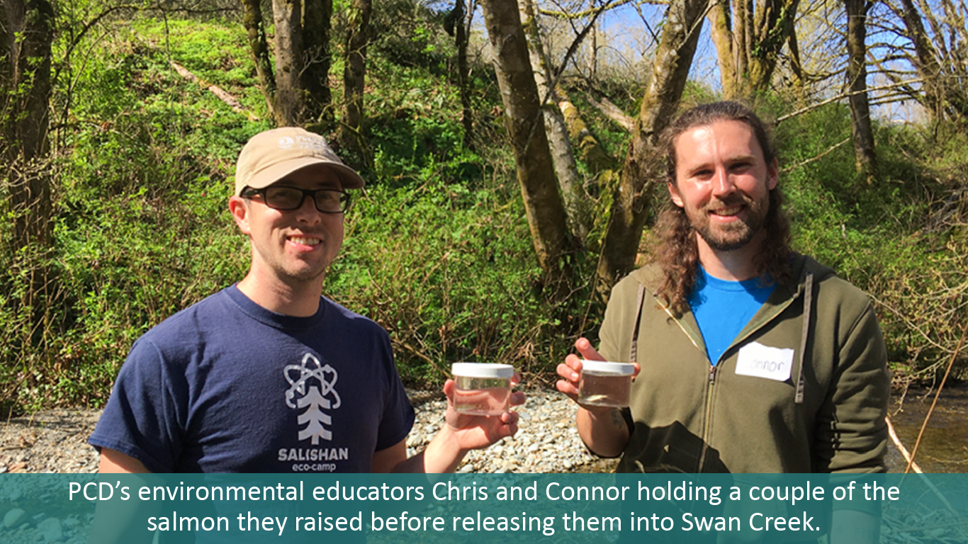 PCD's Environmental educators Chris and Connor holding a couple of the salmon they raised.