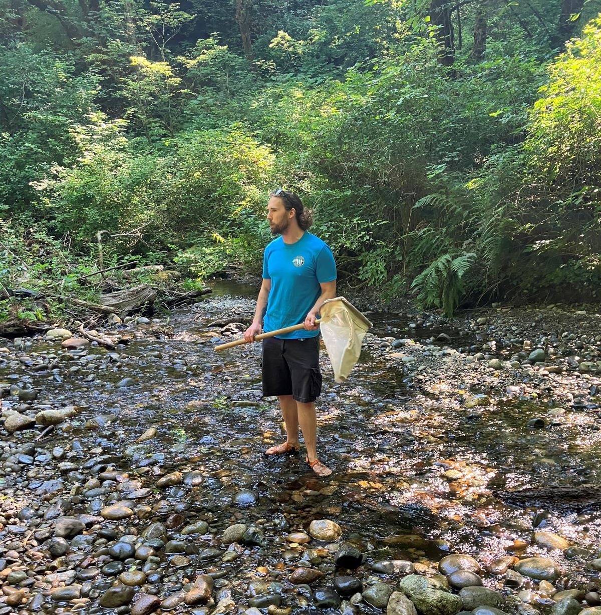 Connor shows Salishan ECO Campers how to collect bugs from Swan Creek