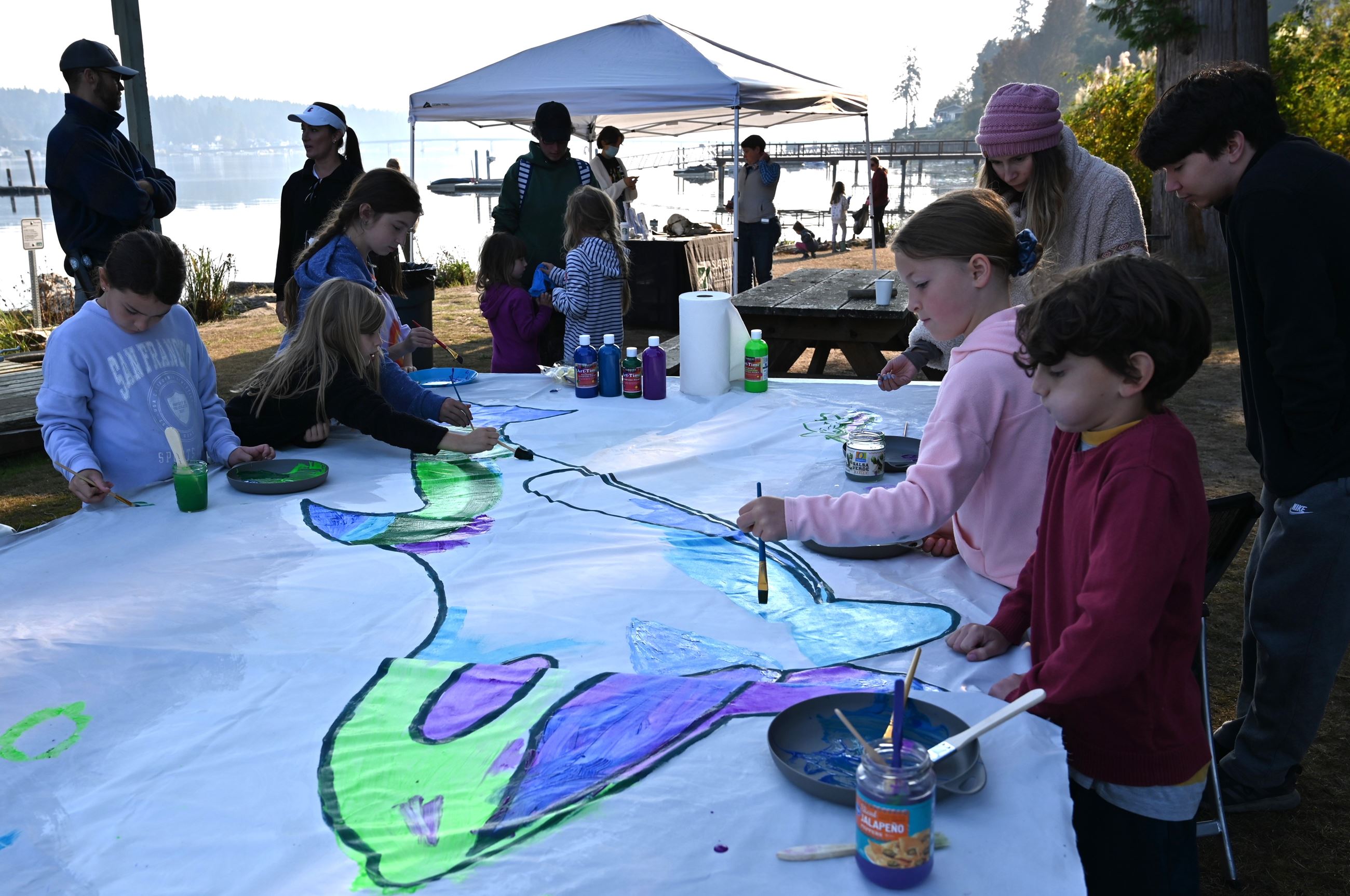Volunteers, including children and adults, painted the Orca Recovery Day banner at PCD’s 2022 event.