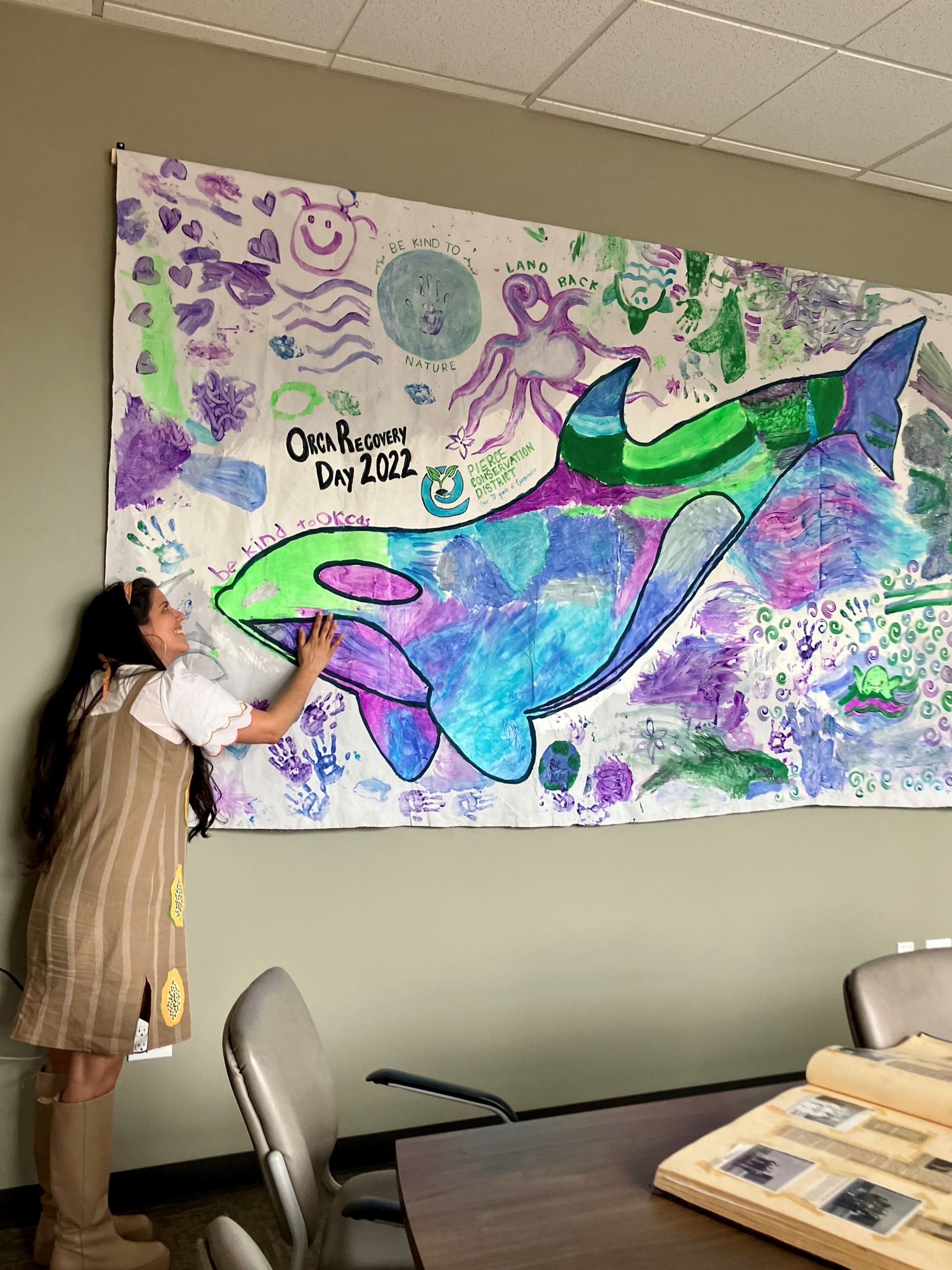 Staff standing next to the banner, right at Orca eye level.