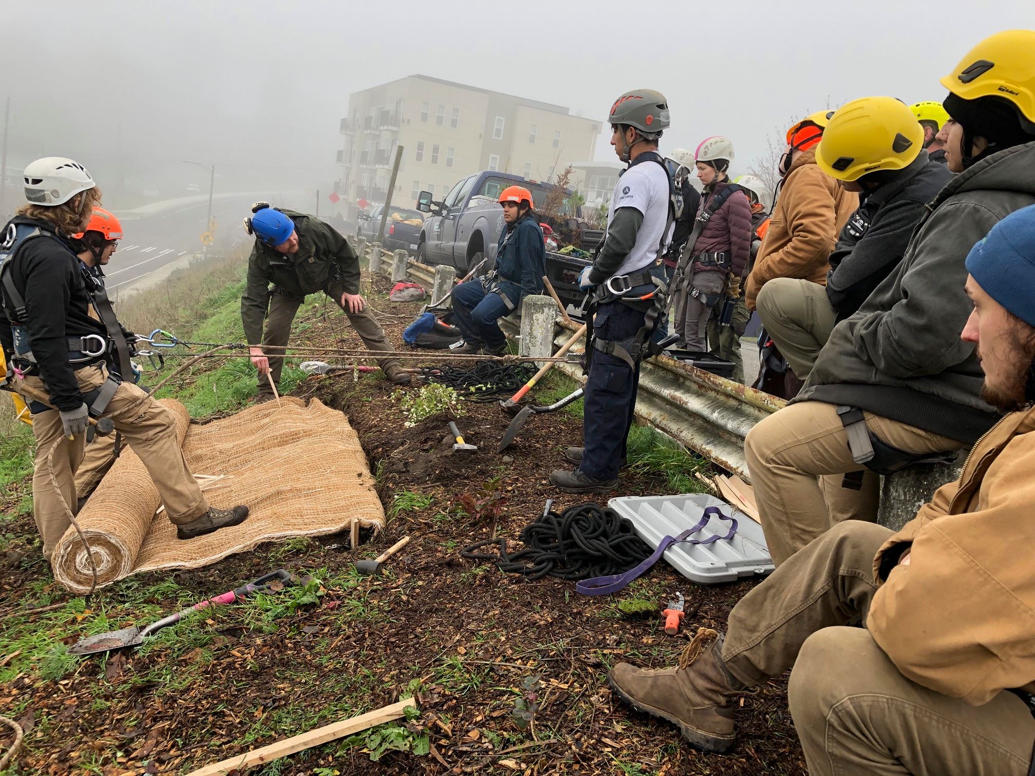 TCD crew members try their hand at erosion control fabric installation after a demonstration from th