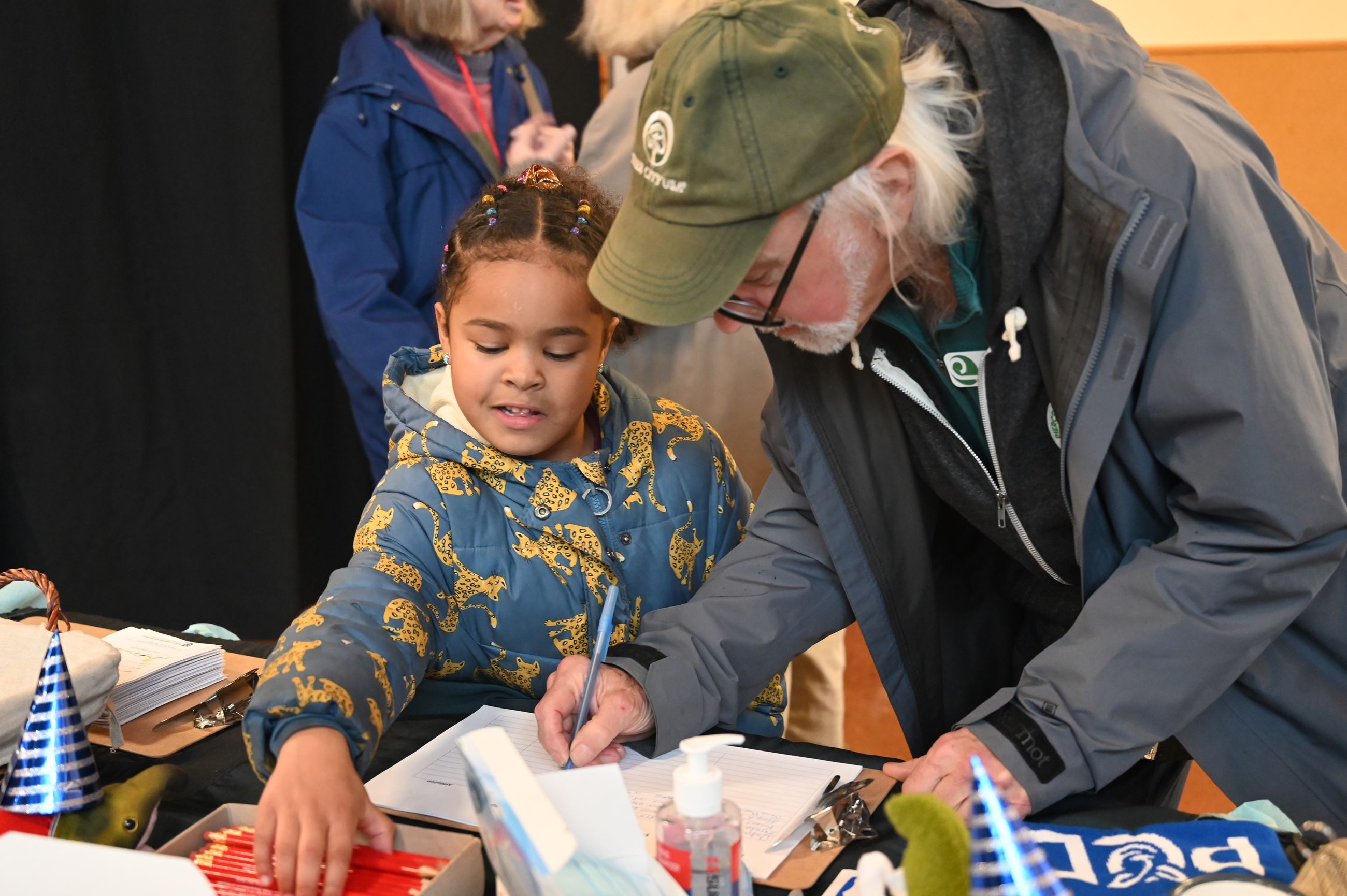 Board member John and a child signing in to the annual celebration