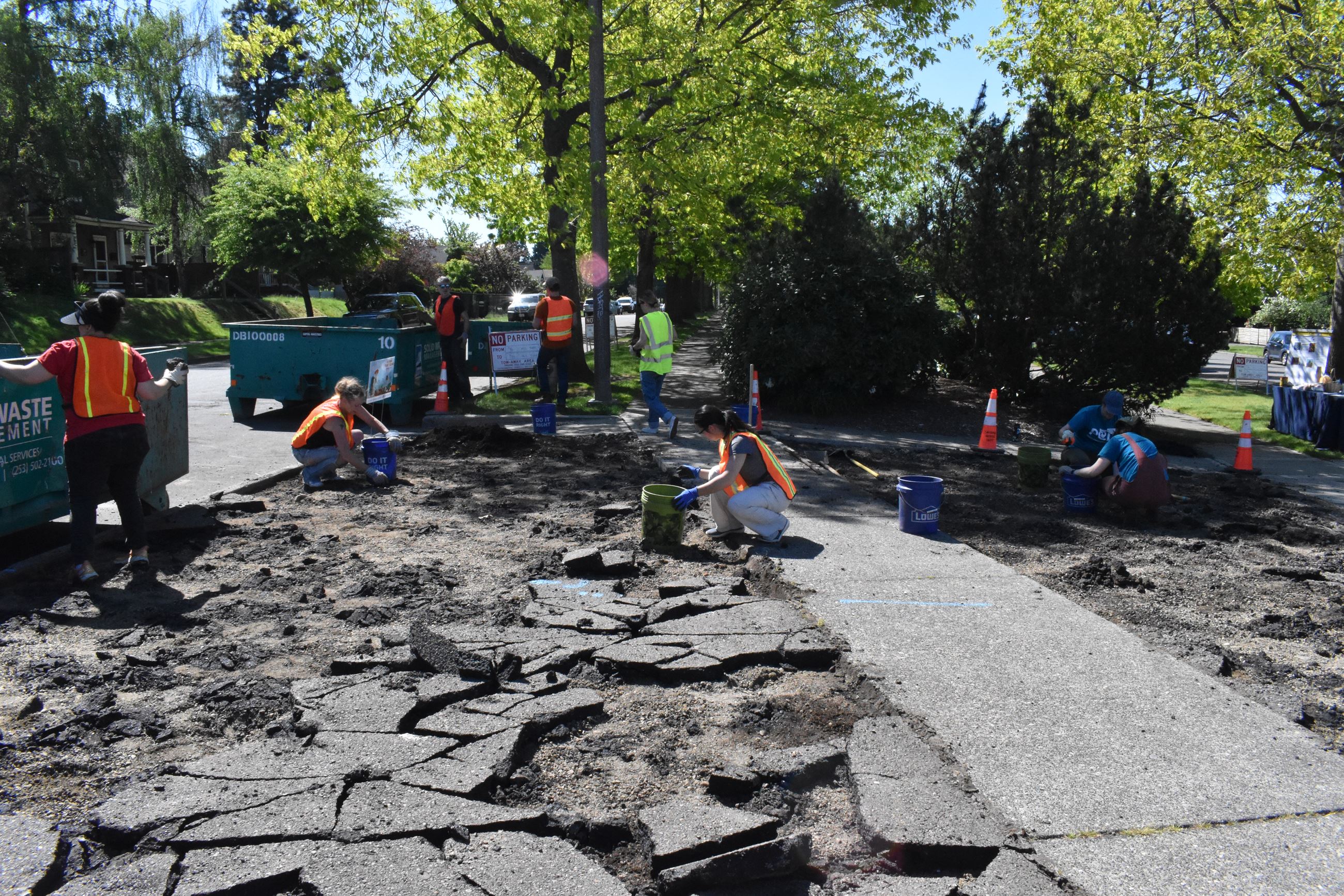 Volunteers remove broken pavement.