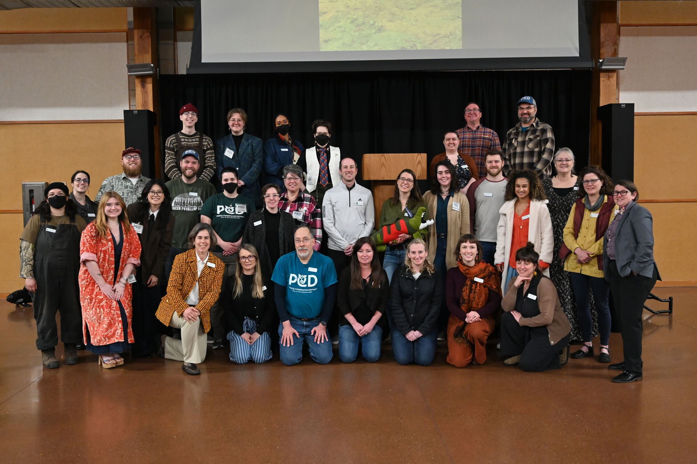 A group of Pierce CD employees smile for a group picture on the stage