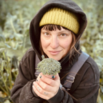 Devon facing forward and holding a broccoli floret