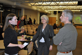 2 women and a man talking in a conference room